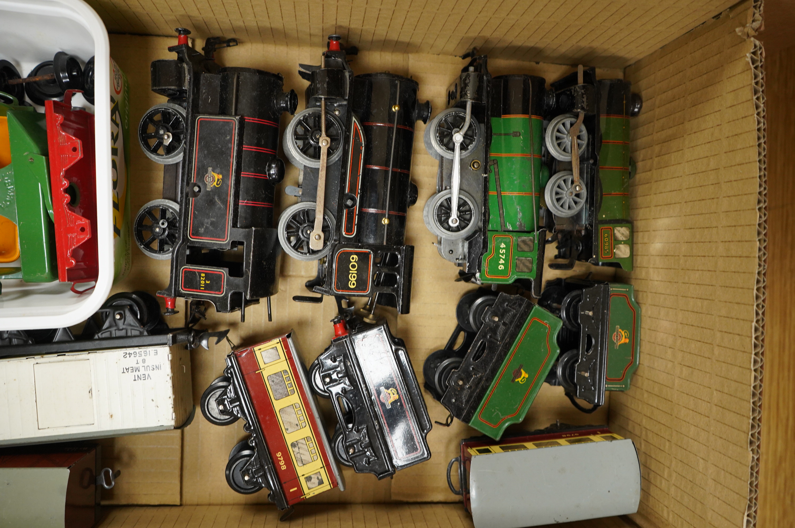 A collection of 0 gauge Hornby tinplate clockwork railway, including four BR locomotives, 17 freight wagons and four wheel coaches, together with a station building, signal cabin, and Goods depot (missing base), plus a f
